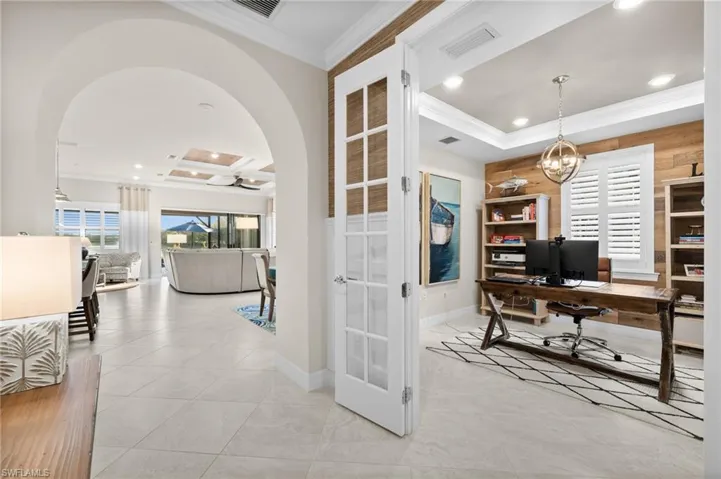 Tiled office with wooden walls, french doors, coffered ceiling, and ornamental molding
