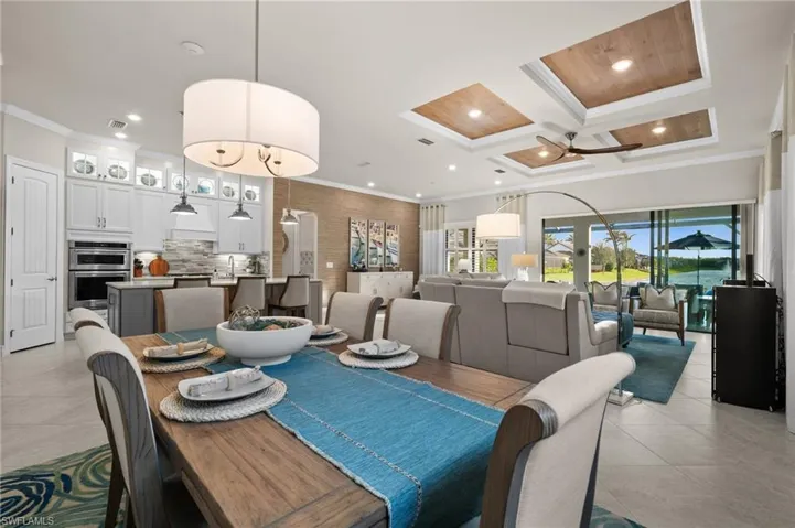 Dining area with beamed ceiling, ceiling fan, crown molding, and coffered ceiling