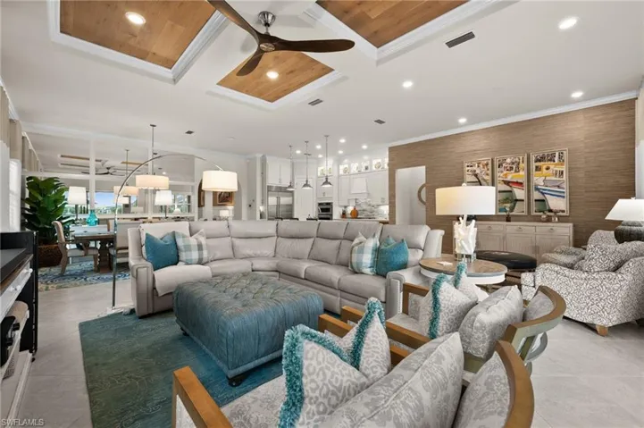 Living room featuring crown molding, ceiling fan, wood ceiling, and coffered ceiling