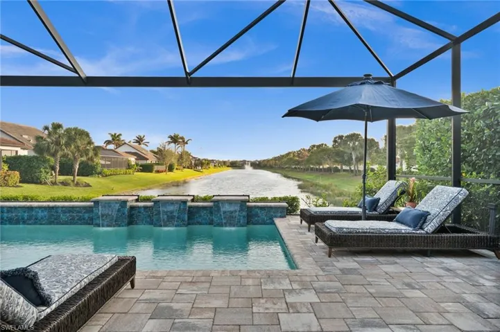 View of pool with a patio, pool water feature, and glass enclosure