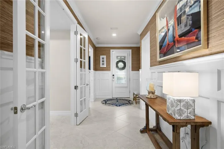 Doorway featuring ornamental molding, light tile patterned floors, and french doors