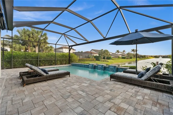 View of pool with a lanai and a patio