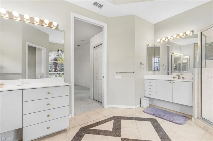 Full bathroom with two vanities and a shower with door