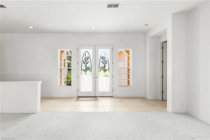 Entryway featuring recessed lighting, tile patterned flooring, carpet floors, and french doors