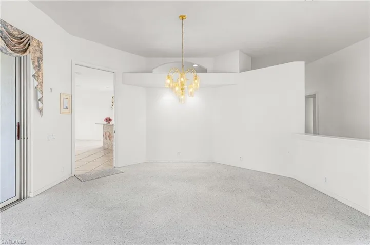 Empty room with a chandelier and speckled floor
