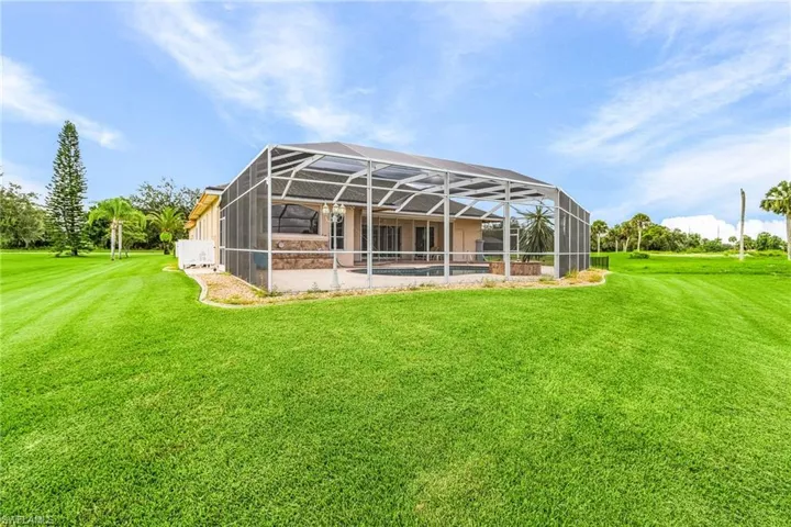 Rear view of property with a yard and a lanai