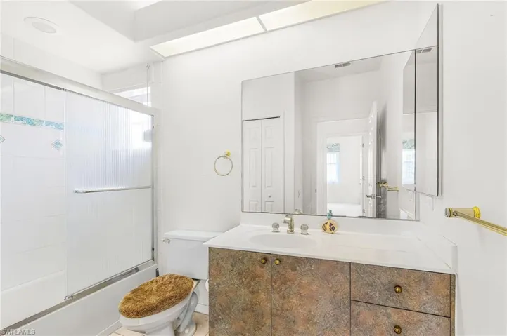 Full bath with vanity and bath / shower combo with glass door