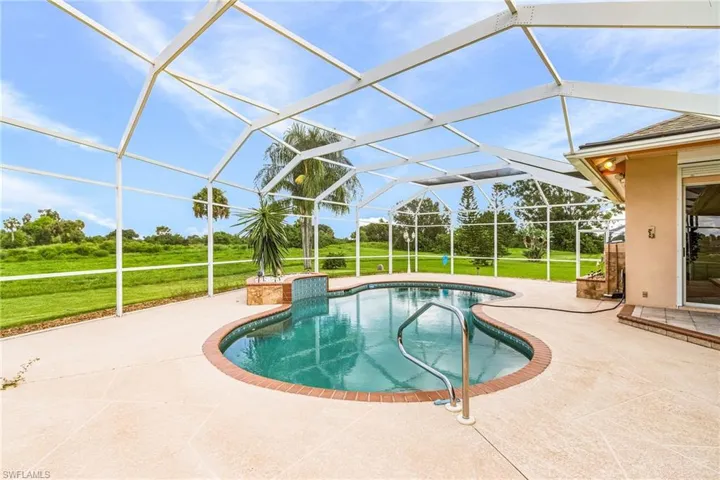 Swimming pool with a patio area, a yard, and a lanai