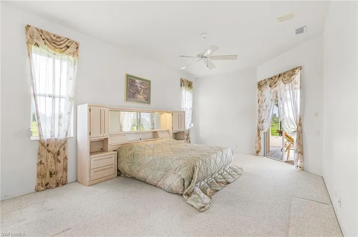 Bedroom featuring access to exterior, light colored carpet, and ceiling fan