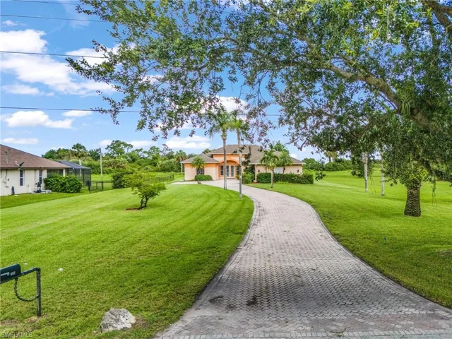 View of property's community featuring a lawn, driveway, and a garage