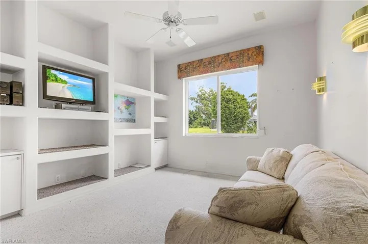 Sitting room featuring built in features, carpet floors, and ceiling fan