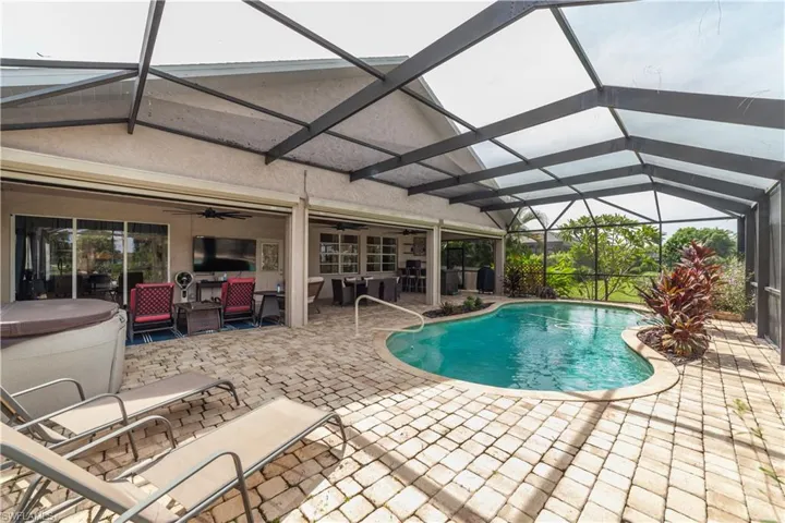 View of pool featuring ceiling fan, a jacuzzi, a lanai, and a patio area