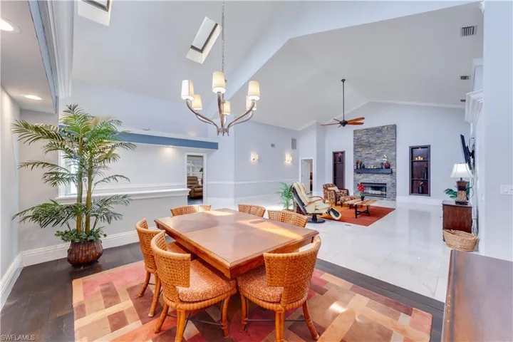 Dining area with a notable chandelier, dark hardwood / wood-style flooring, and high vaulted ceiling