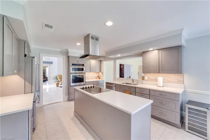 Tiled kitchen with crown molding, beverage cooler, and ceiling fan