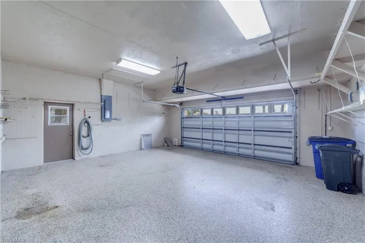 Garage featuring a garage door opener and electric panel