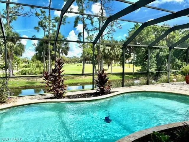 View of pool with screen enclosure and a water view