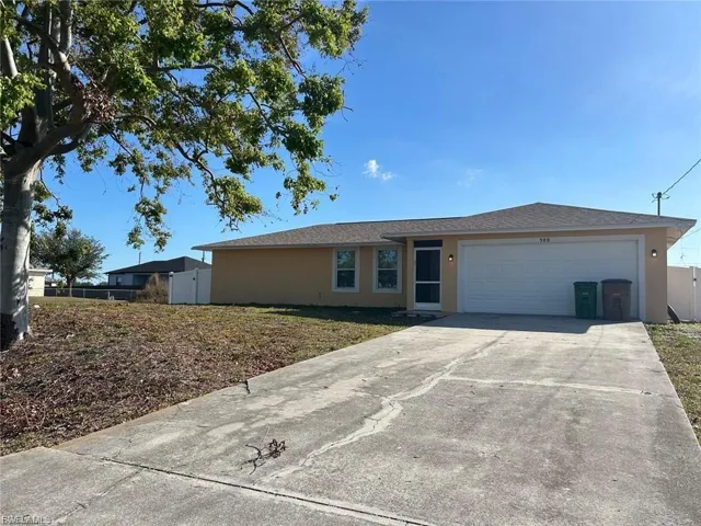 Ranch-style house with concrete driveway, stucco siding, and an attached garage