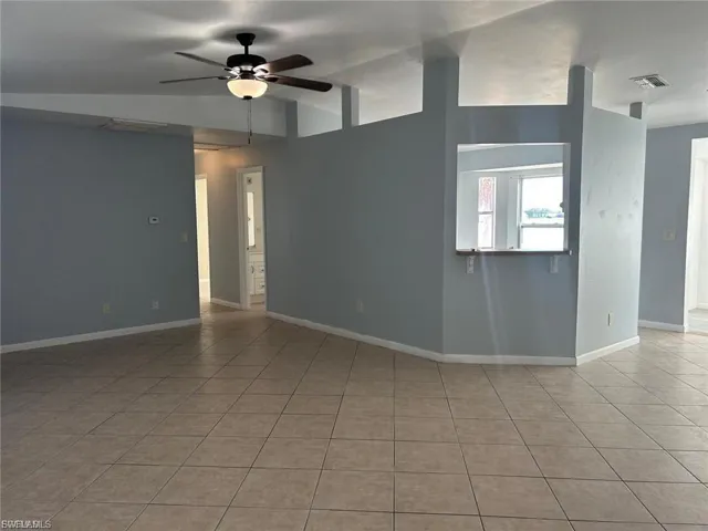Unfurnished living room featuring light tile patterned floors and a ceiling fan