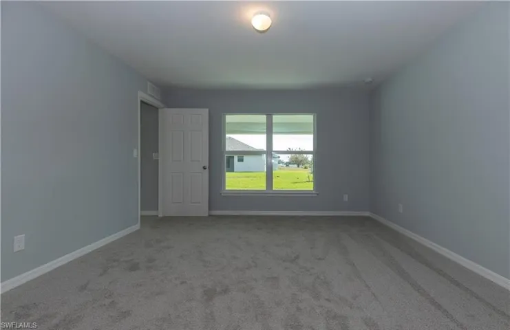 Spare room with light colored carpet and baseboards