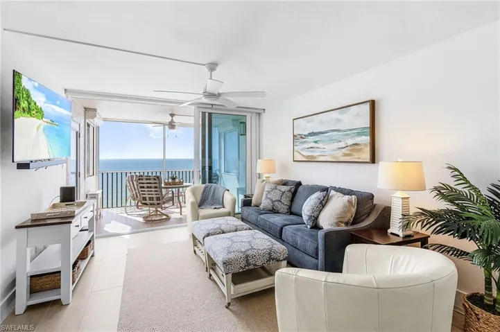 Living room with IMPACT SLIDERS. Plus shutters on outdoor side screens. See hoe the wide plank long tiles go through the screened lanai!