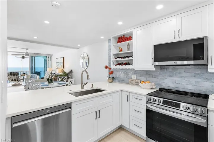 Incredible oversized remodeled kitchen with large bar top space- quartz top, Stainless LG ThinQ Smart Appliances. gorgeous tile backsplash and lots of storage in this kitchen.