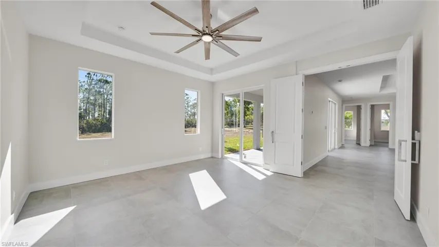 Spare room featuring a raised ceiling and a ceiling fan