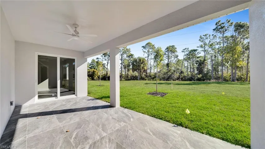 View of patio / terrace featuring a ceiling fan and view of scattered trees
