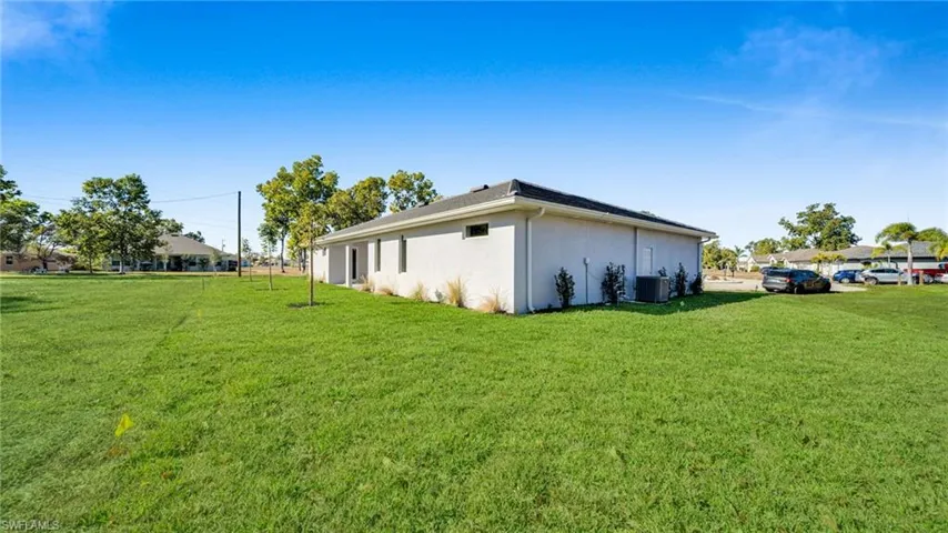 View of property exterior featuring a lawn and stucco siding