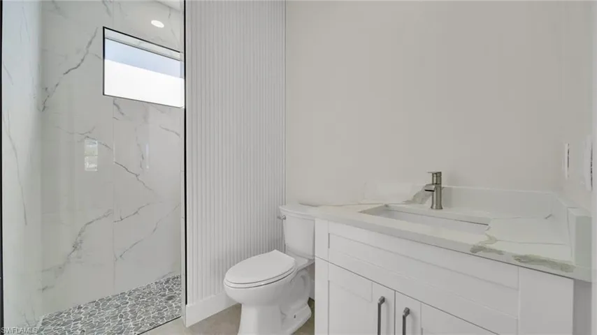 Full bathroom with vanity and a marble finish shower