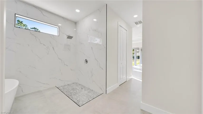 Full bath featuring a marble finish shower, recessed lighting, and a soaking tub
