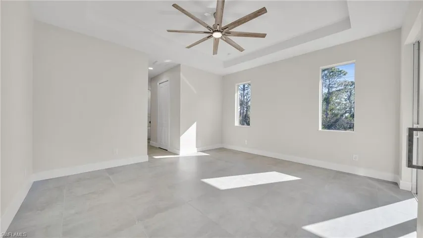 Empty room featuring a ceiling fan and a raised ceiling