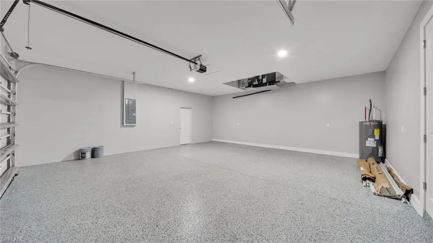Garage featuring electric water heater, electric panel, and recessed lighting