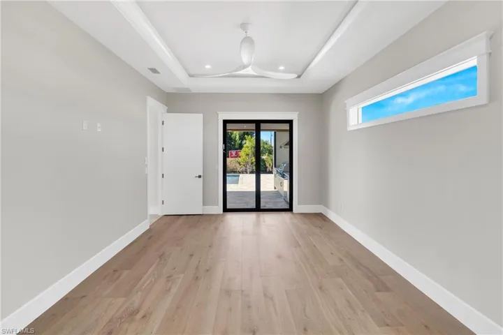 Unfurnished room with light wood-style floors and a raised ceiling