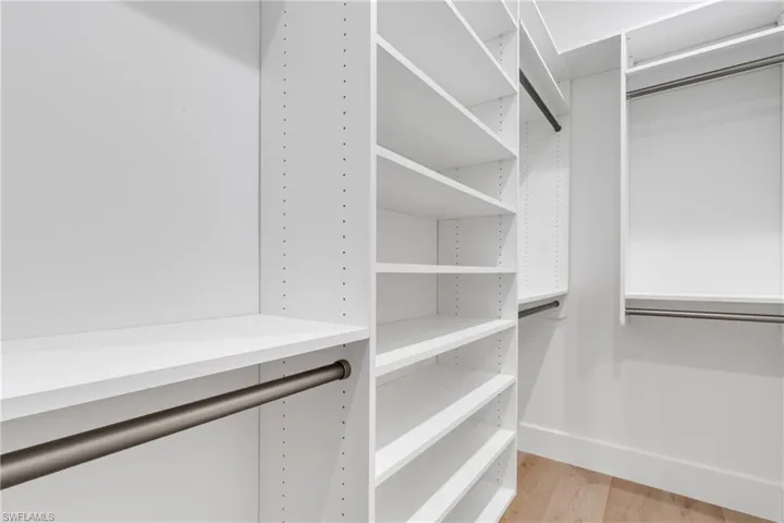Walk in closet with light wood finished floors