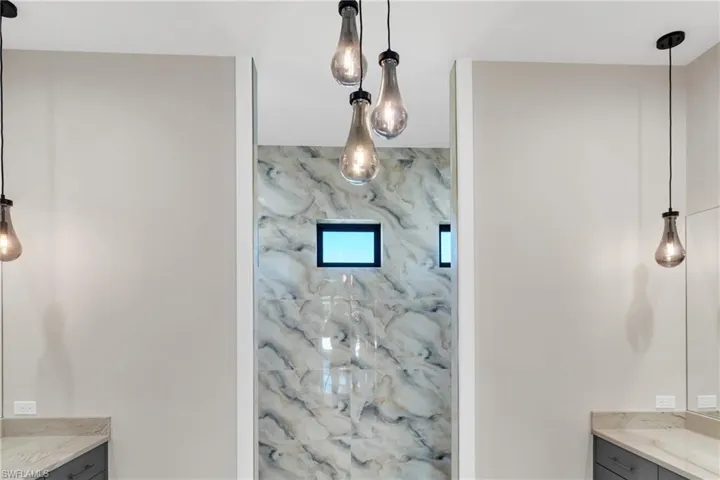 Full bathroom with vanity and a marble finish shower