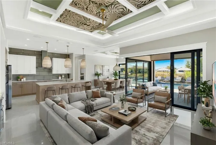 Living room with a ceiling fan, coffered ceiling, and a towering ceiling