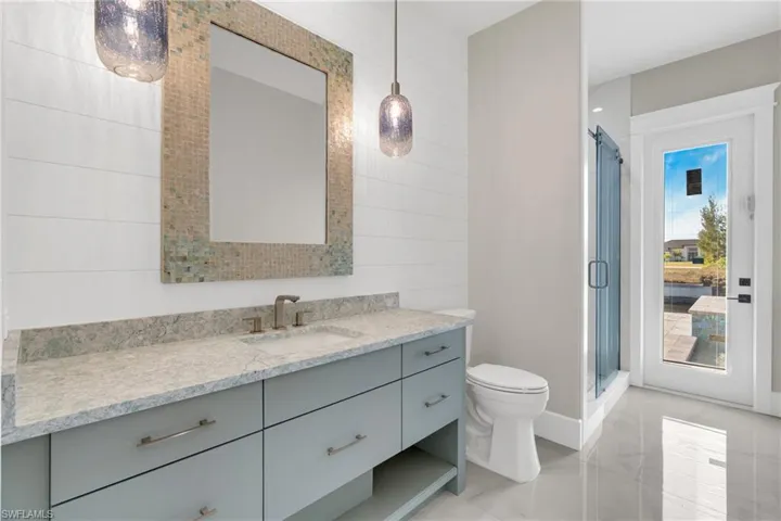 Bathroom with vanity, a stall shower, and tile walls