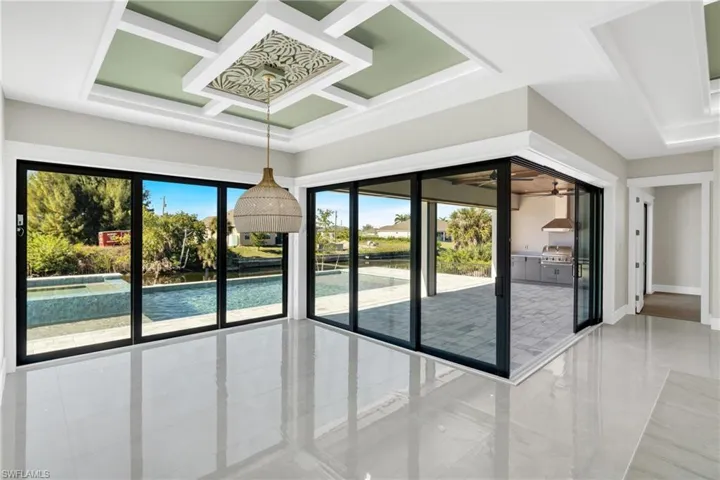 Doorway featuring coffered ceiling and a ceiling fan