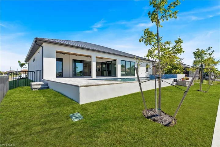 Back of property featuring a patio, stucco siding, ceiling fan, a metal roof, and a standing seam roof