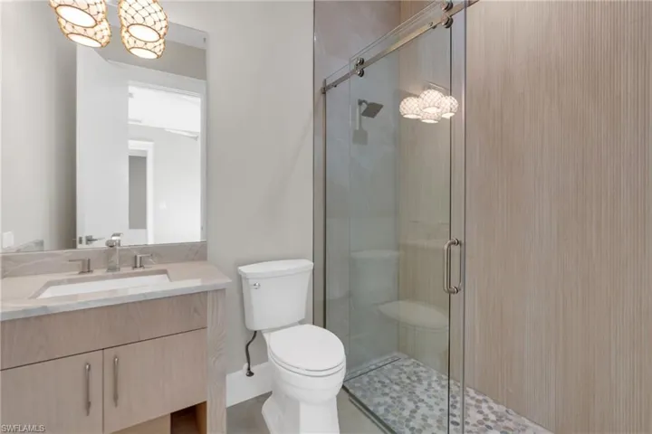 Full bathroom featuring vanity, a shower stall, and a chandelier