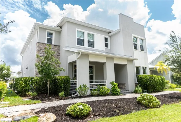 Contemporary multi-story residence featuring a smooth stucco exterior with stone veneer accents