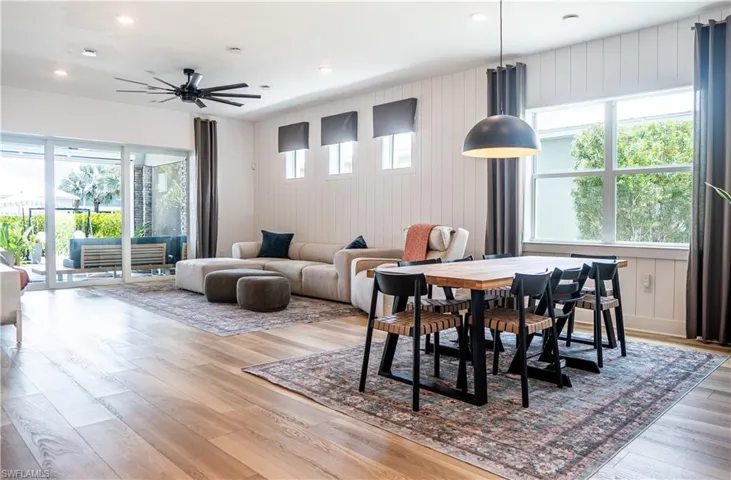 Open-concept living area featuring wood-finish flooring, white shiplap accent walls, and recessed lighting