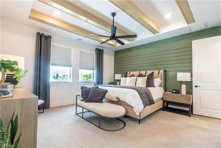 Tray ceiling with exposed wood-finish beams, integrated lighting, and a ceiling fan