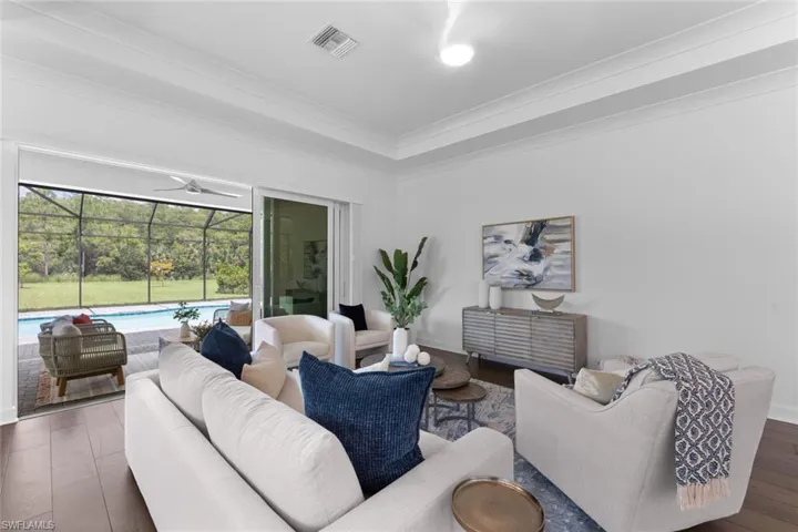 Living room with hardwood / wood-style flooring, crown molding, and ceiling fan