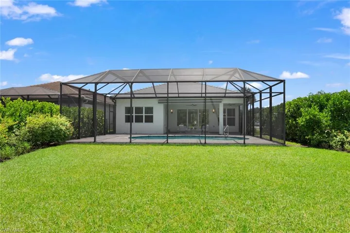 Rear view of house with a lawn and a lanai