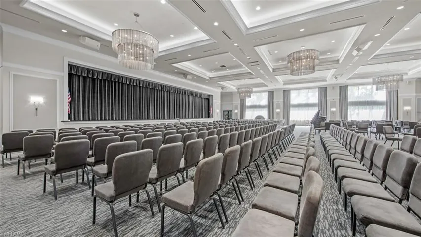 Carpeted cinema room with an inviting chandelier, beam ceiling, ornamental molding, and coffered ceiling