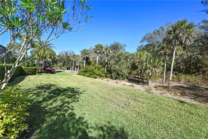 View of green lawn featuring view of scattered trees