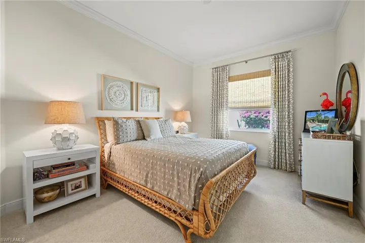 Bedroom featuring ornamental molding and light carpet