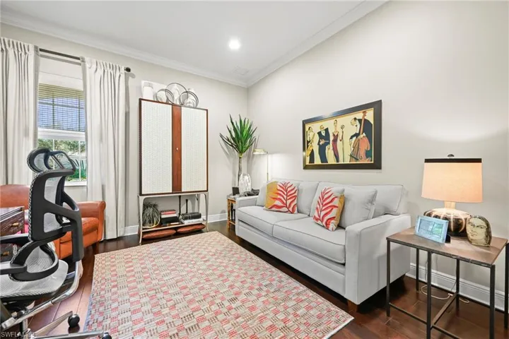 Living room with dark wood-style floors, crown molding, and recessed lighting