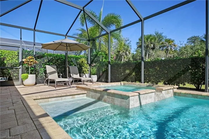 View of swimming pool featuring a lanai, a sunroom, and a pool with connected hot tub